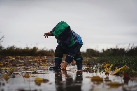Small child standing in a puddle